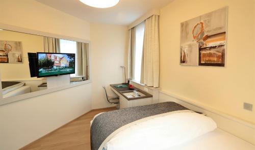 a bedroom with a bed and a tv on a wall at Sorgerhof in Frauental an der Lassnitz 