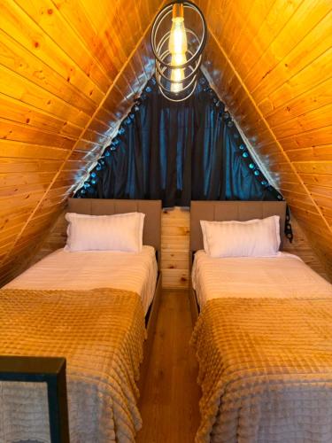 a bedroom with two beds in a wooden house at Ananta in Kobuleti