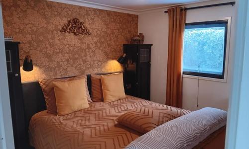 a bedroom with a bed with a large window at Vechtdalchalet, De Wilg in Rheezerveen