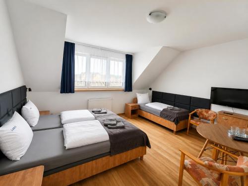 a hotel room with a bed and a table at Dom Wczasowy Larix in Rewal