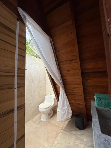 a bathroom with a toilet in a wooden house at Sierra Jungla in Minca