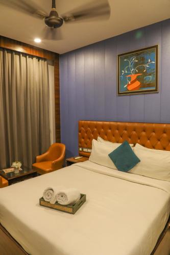 a bedroom with a large bed with two towels on it at Hotel Helios in Zirakpur