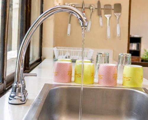 a kitchen sink with a faucet and four candles at La Villa de Sofia in Santa Marta