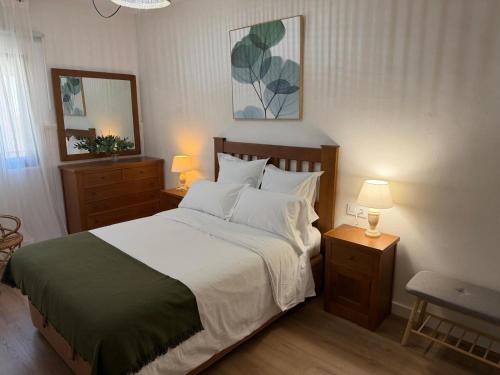 a bedroom with a large bed with white sheets and pillows at Cereza Home in Cabezuela del Valle