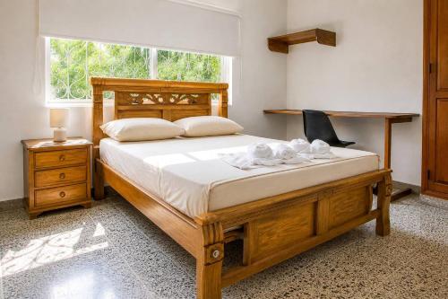 a bedroom with a large wooden bed and a window at La Villa de Sofia in Santa Marta