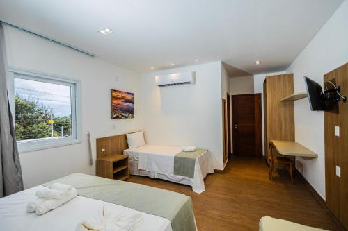 a hotel room with two beds and a window at Landruá Flat in São Luís