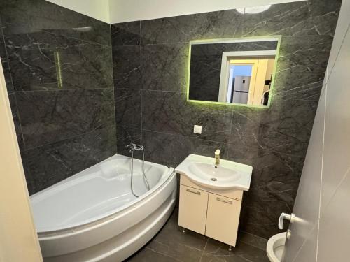a bathroom with a white tub and a sink at Apartament White Tower in Ploieşti