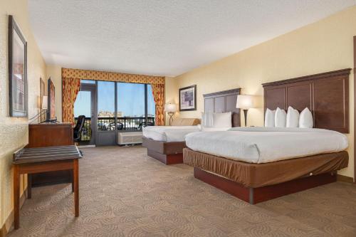 a hotel room with two beds and a balcony at Pier House 60 Clearwater Beach Marina Hotel in Clearwater Beach