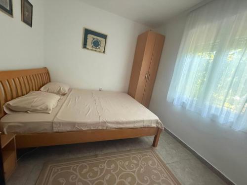a small bedroom with a bed and a window at Apartman LUCIJA, dostupan minimum 7 NOCENJA i VISE, AVAIBLE FOR RENT MINIM 7 NIGHTS AND MORE in Sutomore