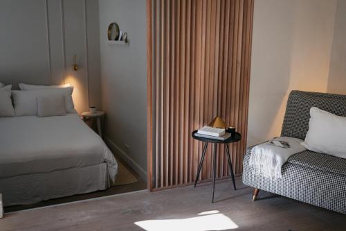 a bedroom with a bed and a side table with a chair at Onder de Linde B&B in Valkenburg
