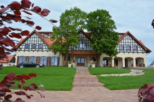 a house with a green lawn in front of it at Hotel Kuźnia Smaków in Małe Pułkowo