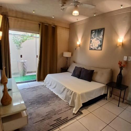 a bedroom with a bed and a large window at Casa Aconchego! in Uberaba