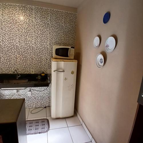 a kitchen with a refrigerator and a microwave on the wall at Casa Aconchego! in Uberaba
