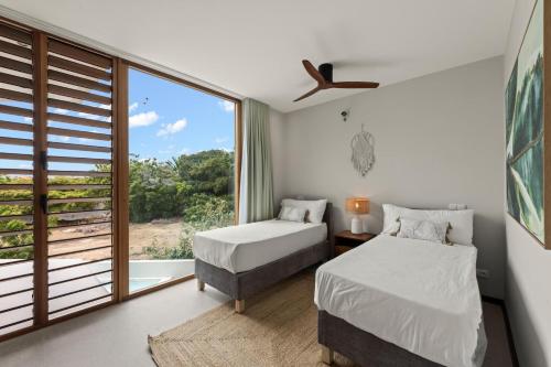 a bedroom with two beds and a large window at Long Lap Pool - Modern Villa - Jan Thiel Beach in Jan Thiel