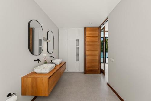 a bathroom with a wooden vanity and a mirror at Long Lap Pool - Modern Villa - Jan Thiel Beach in Jan Thiel