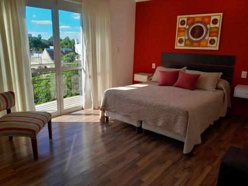 a bedroom with a bed with red walls and a window at Aparts Lio Nell in Colón