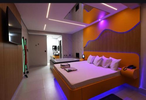 a bedroom with a large bed with purple lights at HOTEL KARINHO - Próximo ao Allianz Parque in São Paulo