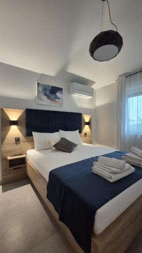 a bedroom with a large bed with a blue blanket at Rimac Apartments in Novalja