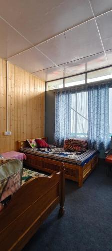 a bedroom with two beds and a window at Saamiyanaa Cloud Nest in Kalimpong