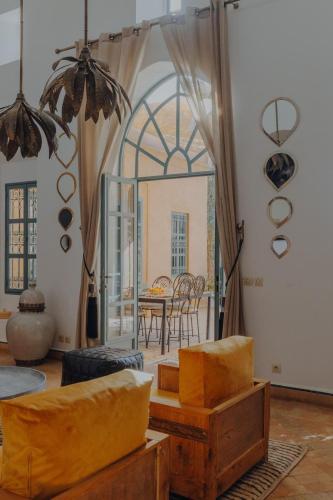 a living room with yellow furniture and a table at Villa Marrakech Beldi in Najem