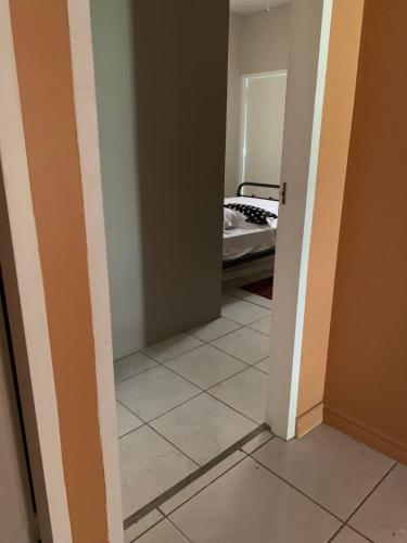 a hallway with a room with a bed and a tiled floor at Alluring Ambrosia in Arouca
