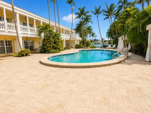 a swimming pool in front of a building with palm trees at Monaco Bay Club 2 in Fort Lauderdale
