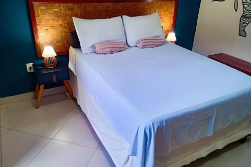 a bed with white sheets and pillows in a room at Casa Marajoara in Soure