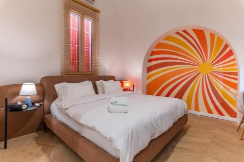 a bedroom with a bed with a large painting on the wall at DAR MEMOIR Apart Hotel in Al Mudawwar