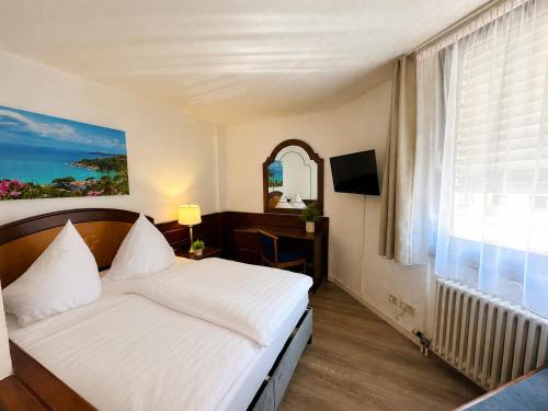 a hotel room with a bed and a window at Hotel Garni Italia in Bühl