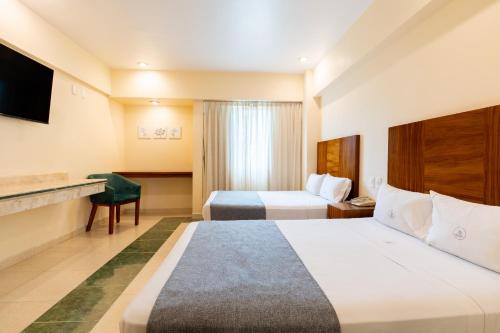 a hotel room with two beds and a television at Hotel Real Del Sol in Guadalajara