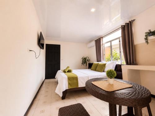a bedroom with a bed and a table and a window at Anluka Estudio Yaguarundi in Puerto Jiménez