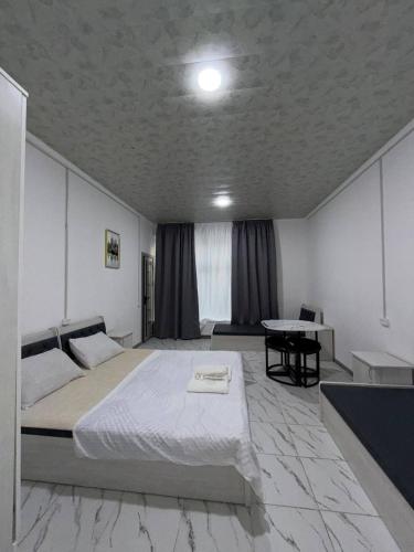 a bedroom with a large bed and a table at 888 отель in Yunusobod