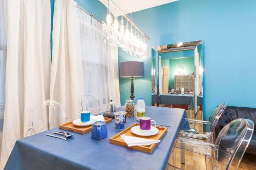 une table bleue avec deux plaques et un miroir dans l'établissement South Kensington Apartment x4, à Londres