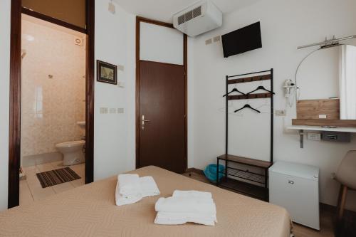 a room with a bed with towels on it at Hotel Grand Prix in Sottomarina