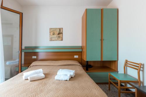 a bedroom with a bed with two towels on it at Hotel Grand Prix in Sottomarina