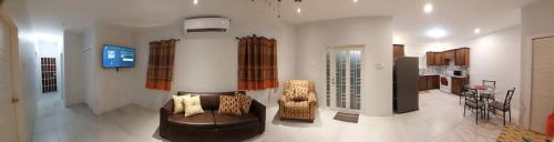 a living room with a leather couch and chairs at Santa Fe in Port-of-Spain