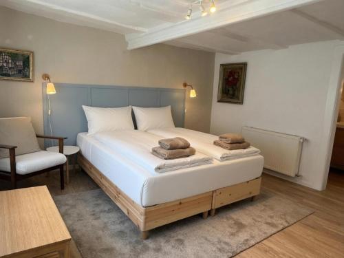 a bedroom with a large bed and a chair at B&B Heckerfeld in Burglahr
