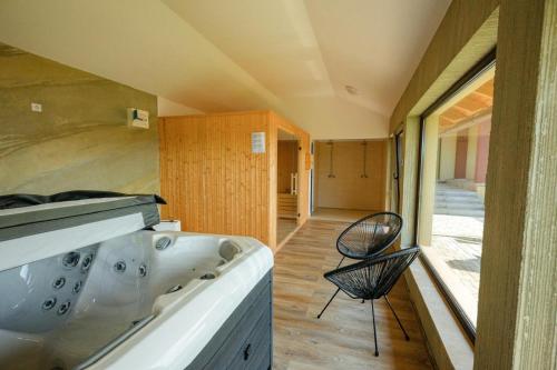 a bathroom with a tub and a chair at Casa Leda in Sovata