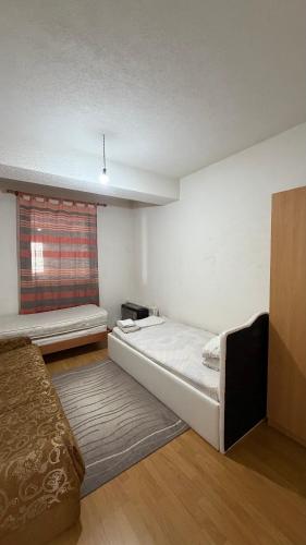 a white room with a bed and a window at Coolbnb Apartment Tetovo in Tetovo