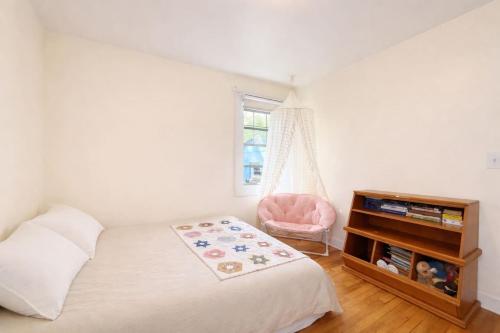 a bedroom with a bed and a chair and a window at Live Oak Home with Garden Studio in Gainesville
