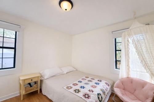 a bedroom with a bed and a chair and a window at Live Oak Home with Garden Studio in Gainesville