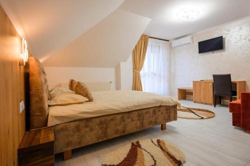 a bedroom with a bed and a television in a room at Casa Leda in Sovata