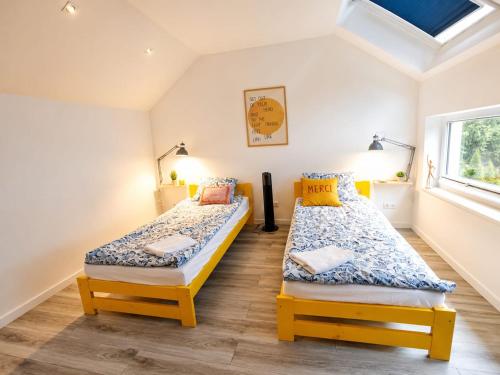 two twin beds in a room with a window at Domki Heaven Kujanki in Kujanki