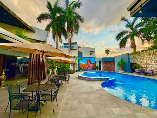 a swimming pool with tables and chairs next to a building at Grann Hotel in Ciudad Valles