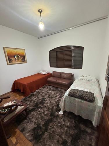 a living room with a bed and a couch at Pousada e Hostel Rodo in São Carlos