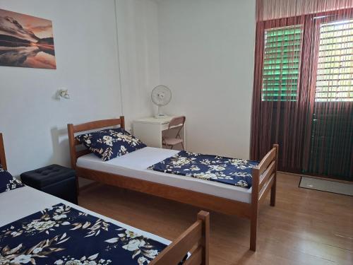 a small room with two beds and a window at Sandra Apartmani 2 in Zaostrog
