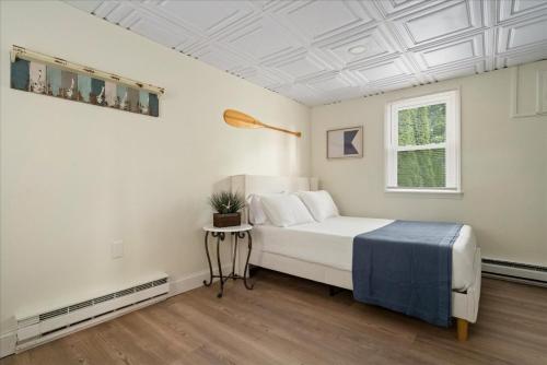 a white bedroom with a bed and a window at The Beachside Co in Sylvan Beach