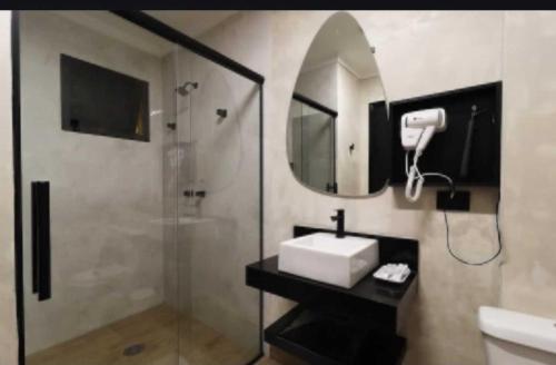 a bathroom with a sink and a shower with a mirror at HOTEL KARINHO - Próximo ao Allianz Parque in São Paulo