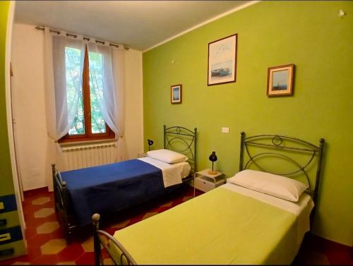 two beds in a room with green walls at Marruvium 1937 in Avezzano