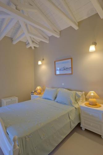 a bedroom with a bed and two tables with lamps at Villa Athena Ermioni in Ermioni